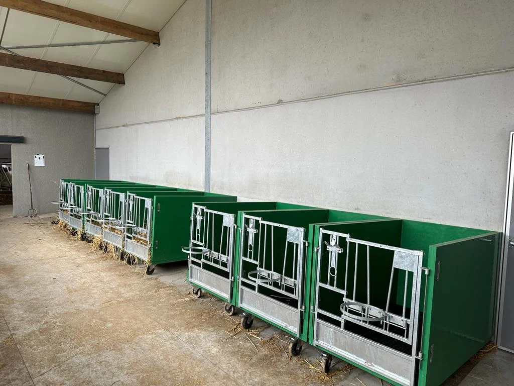 Green Mobibox pens on wheels in a bright barn