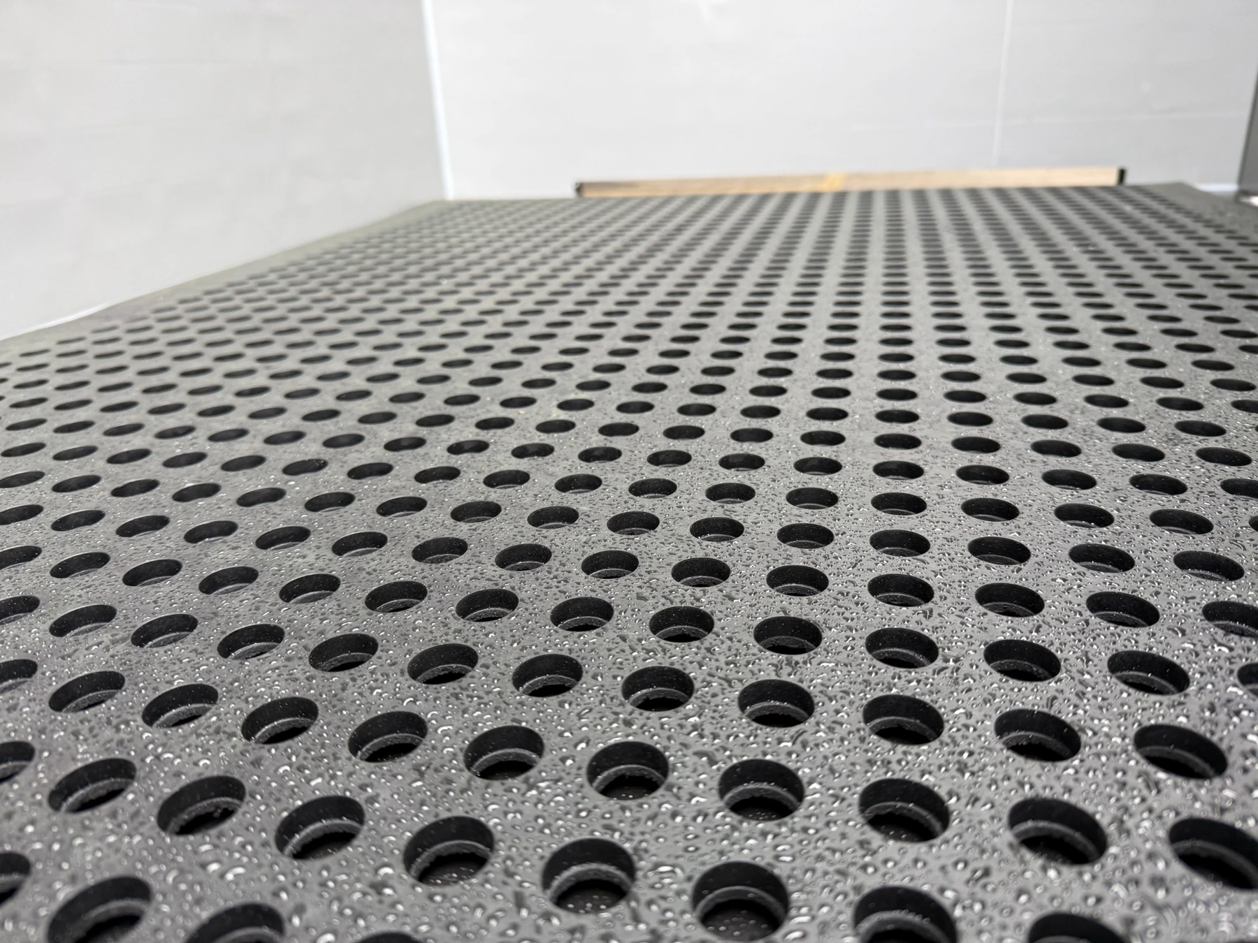 Detail of a perforated comfort mat inside a calf pen